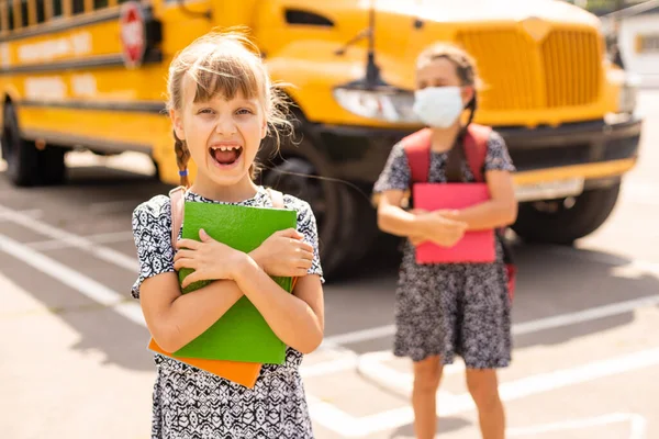 The schoolgirl puts on a mask to prevent colds and viruses. Medical concept. Back to school. Child going school after pandemic over. — Fotografia de Stock