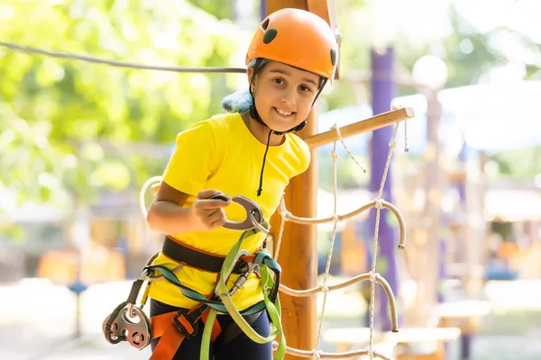 Happy child climbing in the trees. Rope park. Climber child. Early childhood development. Roping park. Balance beam and rope bridges. Rope park - climbing center — Stock Photo, Image