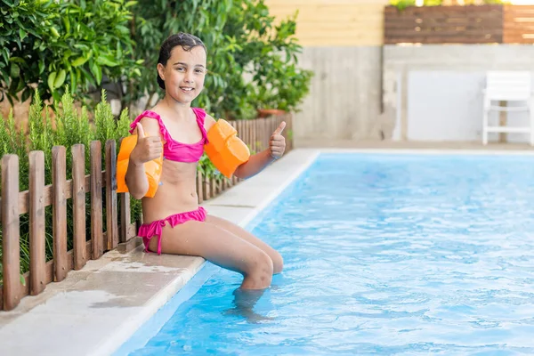 Hezká holčička koupání ve venkovním bazénu a bavte se — Stock fotografie