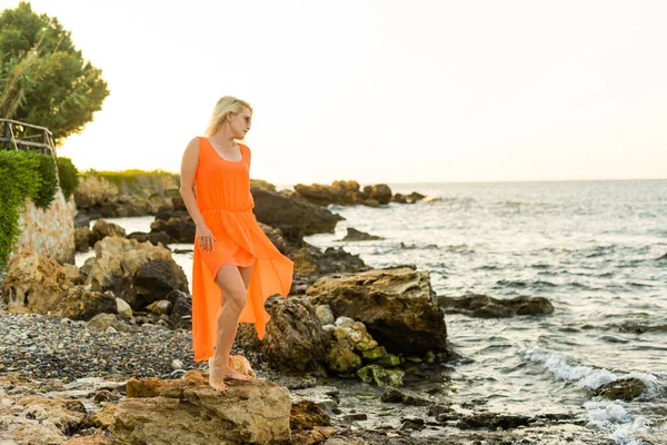 Красива жінка в одязі на кам'яному морському пляжі — стокове фото