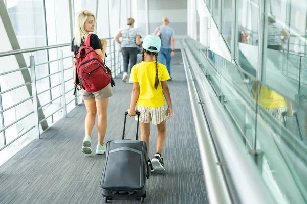 Família no aeroporto. Jovem atraente e filhinha fofa estão prontos para viajar. Conceito de família feliz. — Fotografia de Stock