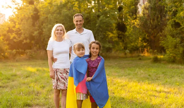 Boldog család ukrajnai zászlóval a mezőn. életmód — Stock Fotó