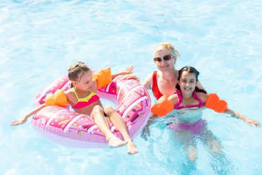Havuzda mutlu bir aile, suda eğleniyor, çocuklu bir anne su parkında eğleniyor, plaj tatili, yaz tatili, tatil konsepti.