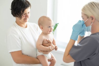 Şırıngalı, gergin anne ve bebeği olan çocuk doktoru.
