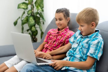 Tatlı çocuklar eğitim için dizüstü bilgisayar, online çalışma, evde öğrenim, uzaktan öğrenim gören kız ve erkek çocukları. Evde eğitim için yaşam tarzı kavramı.