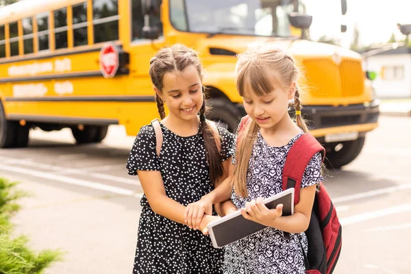 Educação: Amigos estudantes sorridentes prontos para a escola ao lado do ônibus escolar — Fotografia de Stock