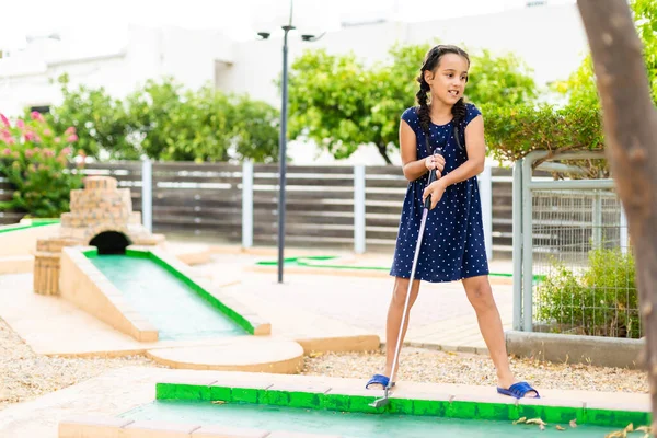 Menina bonito jogar mini golfe em um parque — Fotografia de Stock