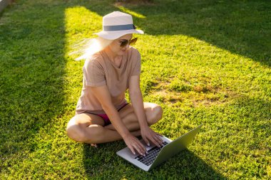 Yüzme havuzunda dizüstü bilgisayar kullanan bir kadın.