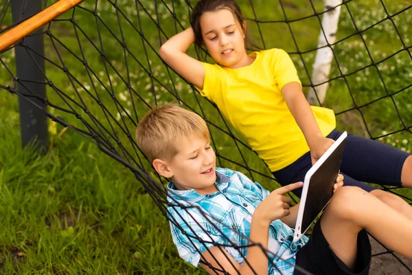 Kinderen in een hangmat in de tuin — Stockfoto