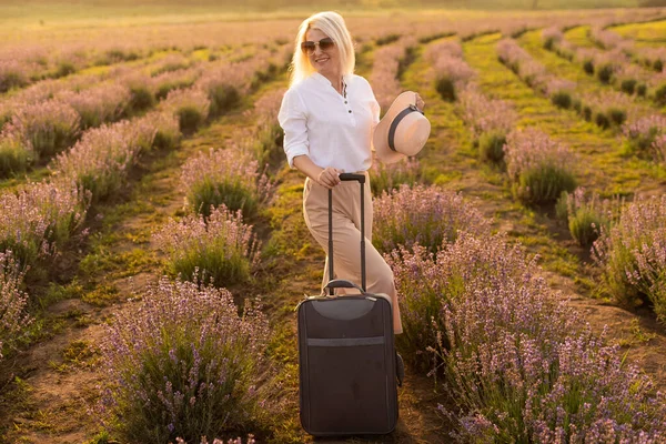 夏日下午，提着手提箱在薰衣草地里的女人 — 图库照片