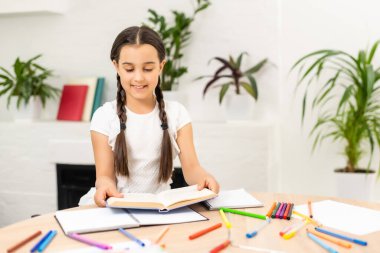 Eğitim ve okul konsepti - gülümseyen küçük kız öğrenci