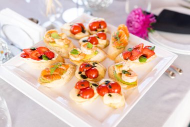 Domates, mozzarella peyniri ve fesleğen dilimleme tahtasında. Geleneksel İtalyan aperatifi veya aperatifi, antipasto. Caprese salatası bruschetta. Kopyalama alanı olan üst görünüm.