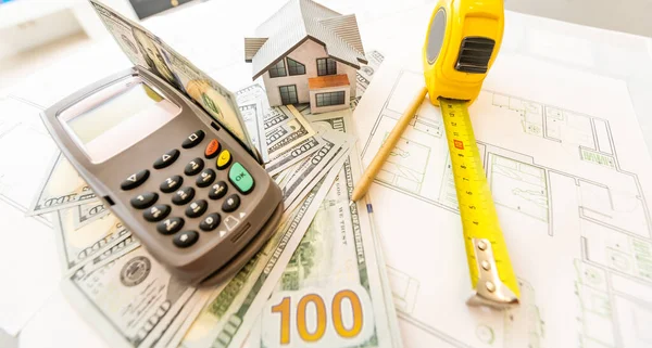 Modelo en miniatura de casa sobre el fondo de un plan de casa, y dinero, y calculadora. —  Fotos de Stock