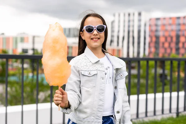 Adorável menina comendo doces-fio dental ao ar livre no verão — Fotografia de Stock
