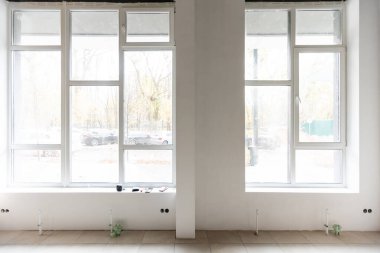 Alışveriş penceresi olan yenilenmiş bir oda. Ahşap zemin ve beyaz duvarları olan boş bir mağaza.