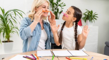 Güzel liseli kız annesiyle evde ödev yapıyor.