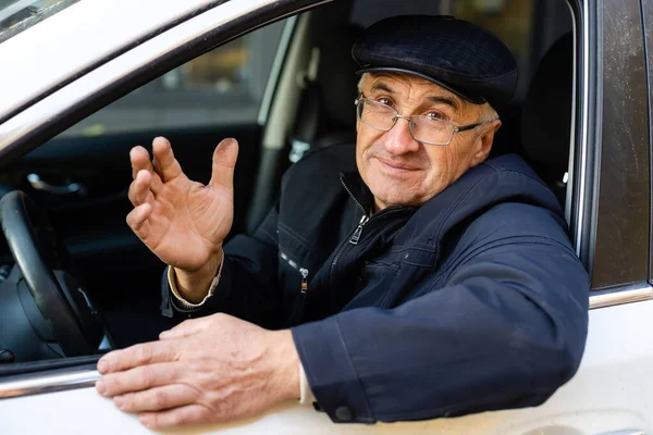 Elderly person driving a car. elderly man in a car — Stock Photo, Image