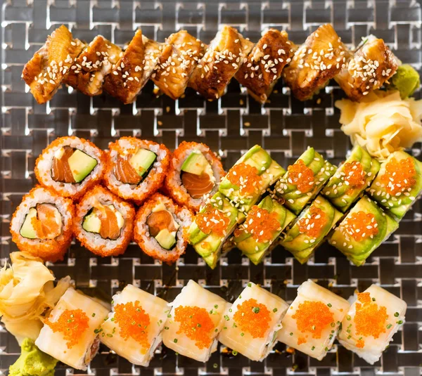 Overhead japanese sushi food. Maki ands rolls with tuna, salmon, shrimp, crab and avocado. Top view of assorted sushi, all you can eat menu. Rainbow sushi roll, uramaki, hosomaki and nigiri. — Stock Photo, Image