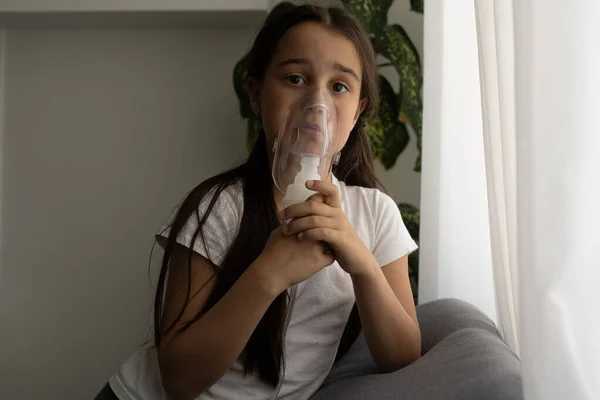 Menina doente faz inalação sobre fundo cinza com espaço de cópia. Menina fazendo inalação com nebulizador em casa. criança asma inalador inalador nebulizador vapor tosse doente — Fotografia de Stock