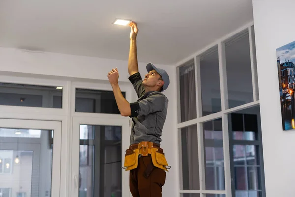 ストレッチ天井にランプを設置する作業員。テキストのスペース — ストック写真