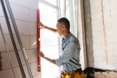 İnşaat işçisi eve pencere kuruyor