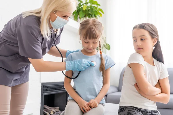Jeune médecin avec petite fille patient se sentant mal inspection médicale avec stéthoscope. — Photo