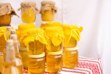 Tarafsız pastel arka planda cam bal kavanozuyla kompozisyon. Alternatif tıp, önleyici tıp.