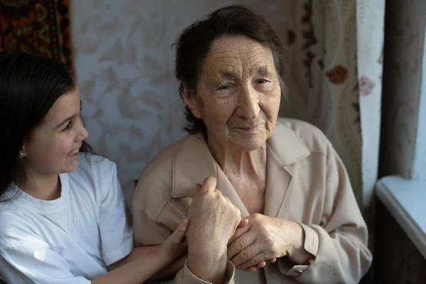 Little baby girl and very old woman. Little child hugging grandmother. Granddaughter — Stock Photo, Image