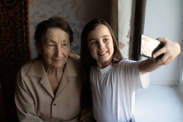 非常老的曾祖母和孙女带着智能手机上网 — 图库照片