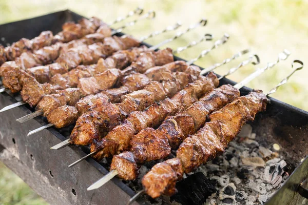 Delicious bbq kebab grilling on open grill, outdoor kitchen. food festival in city. tasty food roasting on skewers, food-court. summer picnic — Stock Photo, Image
