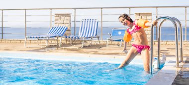 Küçük kız havuzda eğleniyor.