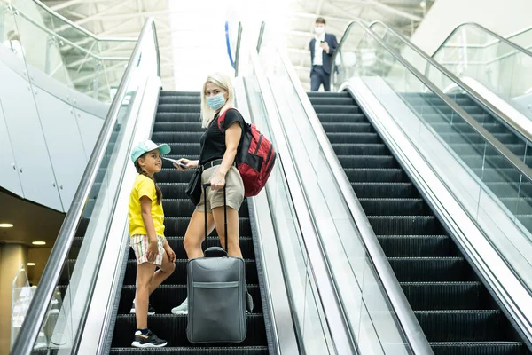 Mother and little daughter go with suitcases to the airport. tourism and travel. — Stock Photo, Image