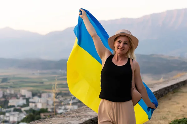 Glückliche Frau mit Fahne der Ukraine in den Bergen — Stockfoto