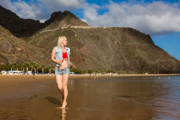 Glückliche unbeschwerte Frau genießt schönen Sonnenuntergang am Strand — Stockfoto