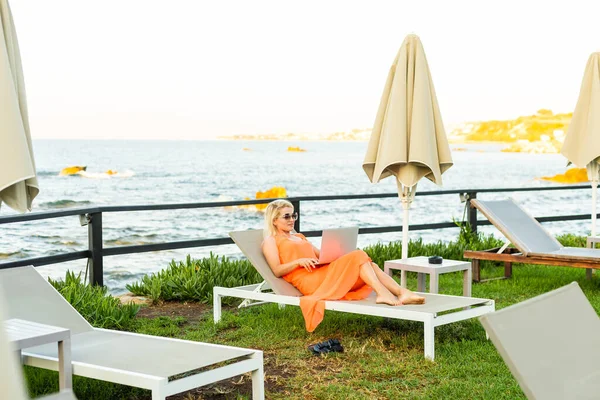 Mulher casual relaxante com um laptop de férias — Fotografia de Stock