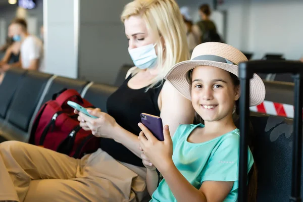 Madre e hija con mascarilla en vacaciones, en el aeropuerto —  Fotos de Stock