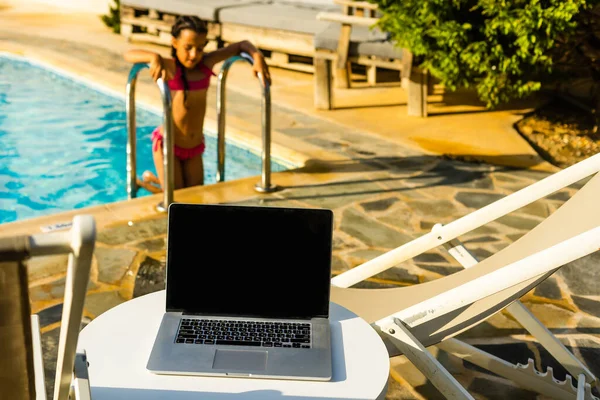 Laptop computer on table pool background — Stock Photo, Image