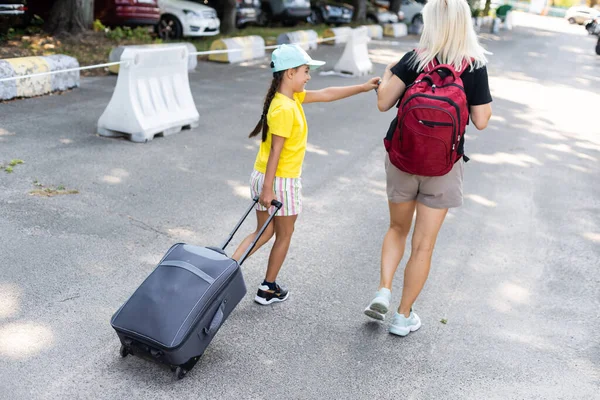 Mãe e filha com mala no estacionamento — Fotografia de Stock