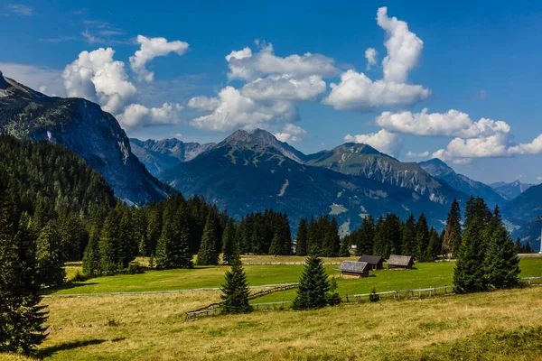 Красивый вид на летний пейзаж в Альпах с чистым горным озером и свежими зелеными горными пастухами на заднем плане — стоковое фото