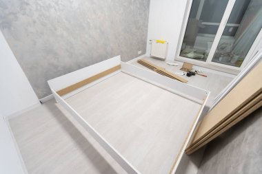 Etek tahtalarının kurulumu, ana yapıştırıcılar duvarın dış köşesine zemin silindirleri, eller.