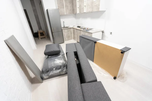 Moderne zwarte en witte doek Bank assemblage, montage van delen van sofa op bruin houten vloer met papier instructie — Stockfoto