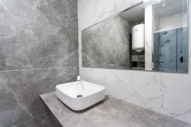 Modern İskandinav iç tasarım konsepti. Tarafsız gri ve bej renkli banyo. Kiralık şık ve rahat bir daire..