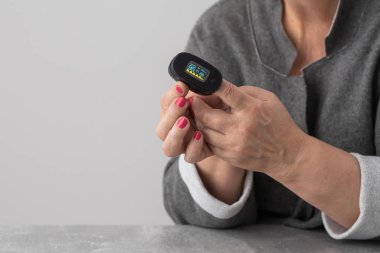 Solunum sistemi fonksiyonunun değerlendirilmesi. Nabız oksimetresi kullanan yaşlı bir hastada kan doygunluğu ve nabız ölçümü. Sağlık ve İlaç