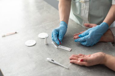 Coronavirus SARS-CoV-2, Covid-19 için antikorlar için COVID-19 testi yapın. Sıhhiyeciler eldiven ile kan testi uygular. Hasta parmaklar, mavi nane arkaplanı