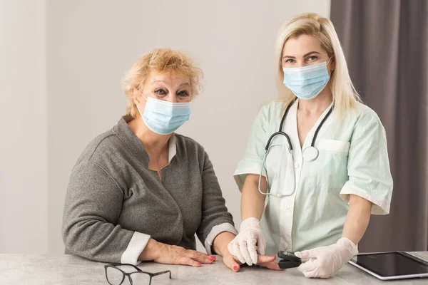 Gesundheitsbesucherin und Seniorin bei Hausbesuch. — Stockfoto