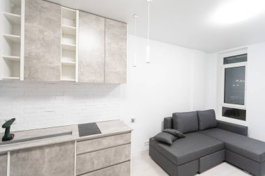 the screwdriver stands next to the new furniture and sofa at home.