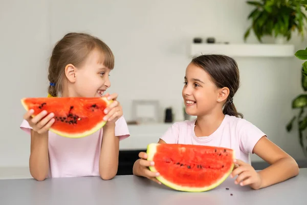 Due bambini che mangiano una fetta di anguria. I bambini mangiano frutta all'aperto. Spuntino sano per bambini. — Foto Stock