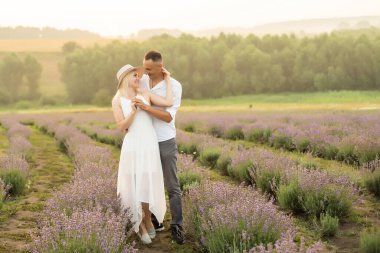 Lavanta tarlasında durup kucaklaşan sevgi dolu bir çift.