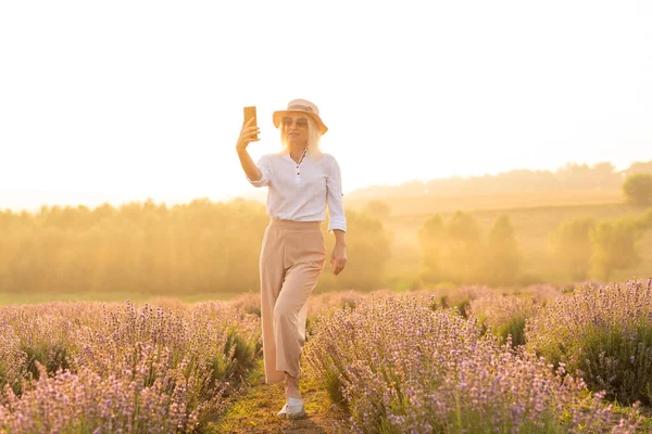 Dłoń osoby robiącej zdjęcie kwiatów na smartfonie — Zdjęcie stockowe