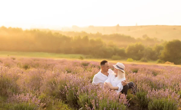 Romantyczna młoda para, mężczyzna i kobieta podczas wakacji bawią się na polu lawendy — Zdjęcie stockowe
